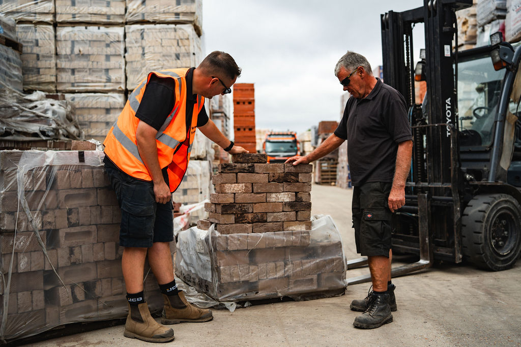 Steward staff checking a stack of bricks with a customer in the yard